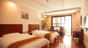 a hotel room with two beds and a desk at GreenTree Inn Lianyungang Guanyun Bus Station Zhenxing Garden Express Hotel in Guanyun +213 photos