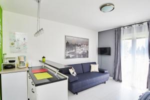 salon z niebieską kanapą i stołem w obiekcie Studio Apartment Vanda w mieście Umag
