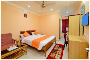 a hotel room with a bed and a tv at Hotel New Sambit International Near Sea Beach And Jagannath Temple in Puri