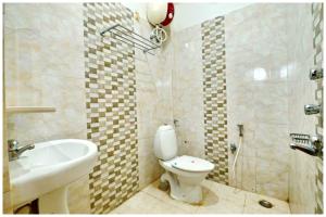 a bathroom with a toilet and a sink and a shower at Hotel New Sambit International Near Sea Beach And Jagannath Temple in Puri +18 photos