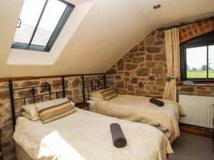 - 2 lits dans une chambre avec un mur en pierre dans l'établissement Corn House, à Plaish 77 autres photos