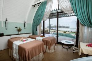 two beds in a room with a pool at CaspiMayr Retreat Beach Resort in Baku +18 photos