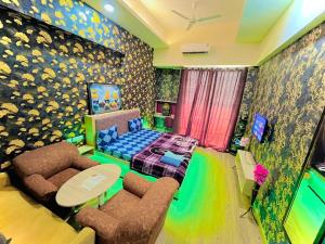 a room with a bed and a table and chairs at Singh Comfy Stay At Mall in Ghaziabad