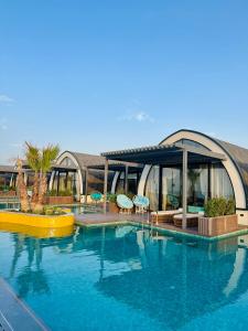 een groot zwembad met stoelen en een gebouw bij Caspi Mayr in Baku +13 foto's