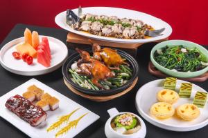 a table topped with plates of food with different foods at Sheraton Zhongshan Hotel in Zhongshan