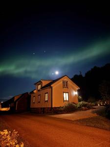 Traditional Nordlandshus in Lofoten - Sea and Mountain View في Vestvågøya: منزل بالشفق في الليل