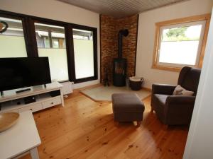 a living room with a flat screen tv and a couch at Ferienhaus in Clausthal-Zellerfeld mit Terrasse in Clausthal-Zellerfeld