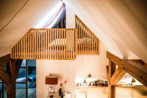 Una escalera de madera en una habitación con techo en Designer Apartment In Historic Pond House, en Freudenfeld