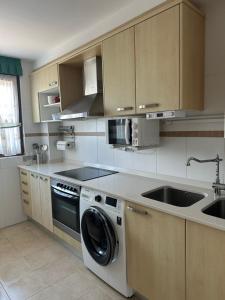 a kitchen with a washing machine and a sink at El Capricho de la Hayuela in Ayuela +18 photos