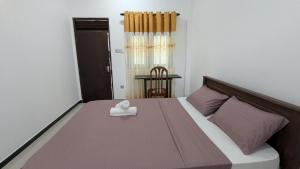 a bedroom with a large bed with a white towel on it at Waveo Homestay Polhena in Matara +17 photos