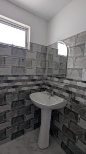 a bathroom with a sink and a brick wall at Waveo Homestay Polhena in Matara