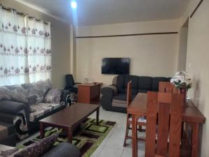 a living room with a couch and a table at Faith Apartment in Gatunga