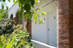 una casa de ladrillo con una puerta blanca y una pared de ladrillo en Le Lido, en Propriano