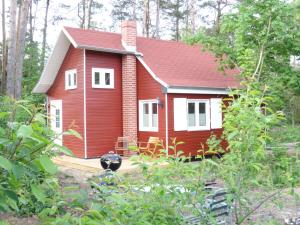 uma pequena casa vermelha e branca na floresta em Schwedenhaus im Grünen em Oranienburg