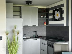 una cucina con mobili bianchi e un lavandino di Studio Relax a Büsum