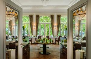 comedor con mesa, sillas y ventanas en Hotel Louis C. Jacob en Hamburgo