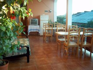 a room with a table and chairs and a tv at Guest House Machaxela in Gonio