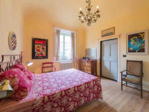 - une chambre avec un lit rose et un lustre dans l'établissement Casa Francesca, à Finale Ligure