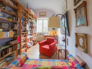 a living room with a red chair and bookshelves at Casa Francesca in Finale Ligure
