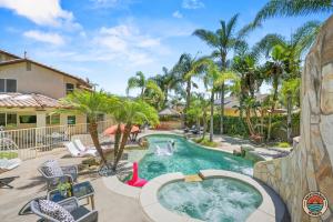 a pool in a yard with palm trees at The Ultimate Escape Pool, Slide, Gym plus Games! in El Cajon