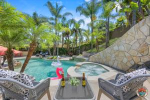 una piscina con 2 sillas y una mesa con botellas de vino en Villa Paradiso, en El Cajon