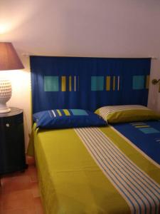 Schlafzimmer mit einem Bett mit einem blauen und gelben Kopfteil in der Unterkunft Loft Giulia in Torre Santa Sabina