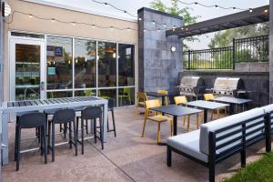 a patio with tables and chairs and a grill at Home2 Suites by Hilton Roseville Minneapolis in Roseville