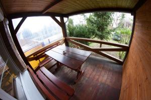 eine Holzterrasse mit einem Holztisch und einer Bank darauf in der Unterkunft Pension Thaya in Znojmo