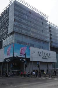 un grand bâtiment en verre avec des personnes qui marchent devant lui dans l'établissement Viru väljak 6 Apartment, à Tallinn