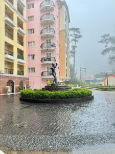 una fuente frente a un edificio rosa en 2-Bedroom Ladera Suites, en Baguio