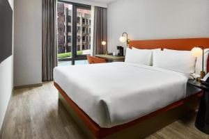 a hotel room with a large bed and a window at The George At Columbia Harlem, Tapestry Collection By Hilton in New York