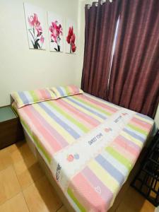 a small bed in a room with a curtain at 2BR Condo Unit at San Remo Citi de Mare in Cebu City