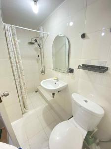 a white bathroom with a toilet and a sink at 2BR Condo Unit at San Remo Citi de Mare in Cebu City