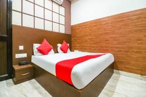 une chambre avec un grand lit avec des oreillers rouges dans l'établissement Hotel O Cra, à Hisār