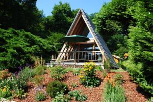 a small cabin with an umbrella in a garden at Ferienhaus Adlerhorst in Billerbeck +7 photos