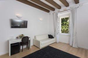 a living room with a white couch and a window at Klarisa Palace Rooms in Dubrovnik