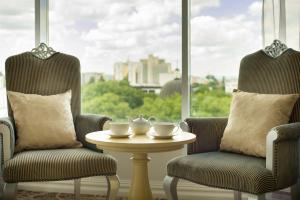 two chairs and a table in front of a window at Bristol Central Park Hotel in Chişinău