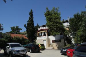 un parcheggio con auto parcheggiate di fronte a un edificio di Bed & Breakfast Novalja Inn a Novalja (Novaglia)