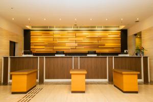 a hotel lobby with a reception counter and benches at Hearton Hotel Nishi Umeda in Osaka