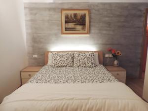 a bedroom with a bed and a painting on the wall at Nido nelle Dolomiti Apartment in Marilleva