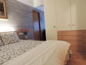 a bedroom with a bed and a dresser and flowers at Nido nelle Dolomiti Apartment in Marilleva