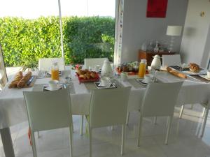 Au Coeur Du Vignoble في أورشويليه: طاولة بيضاء عليها كراسي وطعام