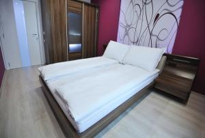a small bed in a room with purple walls at Delfin Apartment in Varna City