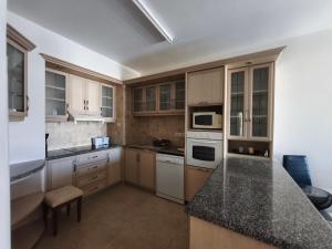 a kitchen with white appliances and a black counter top at Danaos Nava in Paphos City