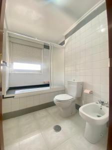 a white bathroom with a toilet and a sink at Apartamento Ponte Stay 33 in Ponteareas