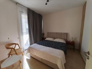 a bedroom with a bed and a window and a chair at Danaos Nava in Paphos City +31 photos