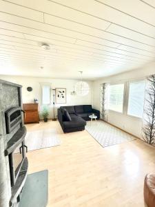 Una sala de estar con un sofá y una chimenea. en Polar Night Wooden House with Sauna, en Sodankylä