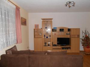 a living room with a couch and a flat screen tv at Ferienwohnung Wünsche in Crostau