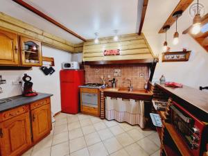 a kitchen with a red refrigerator and a sink at Mon repos bien merite in Eppe-Sauvage