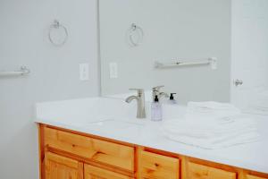 a white bathroom with a sink and a mirror at 5040 Sqft l Sleeps 25 l Near Ski & Downtown SLC in West Jordan +91 photos